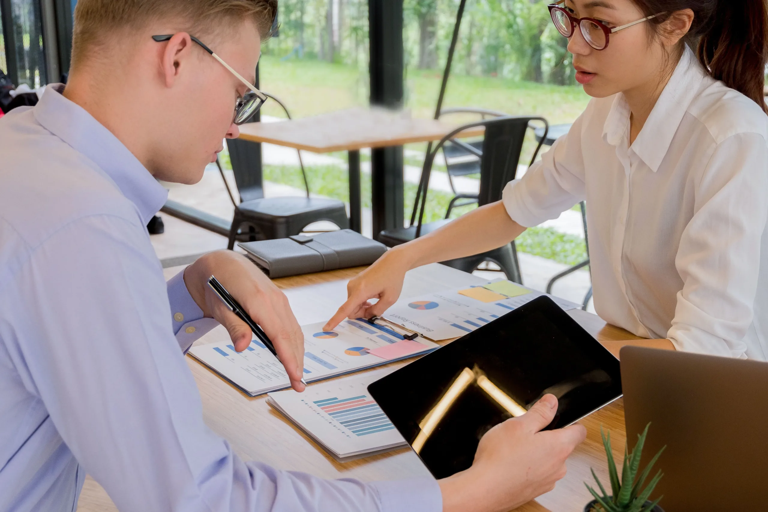 Business professionals reviewing financial reports for signs of debt restructuring needs in Singapore