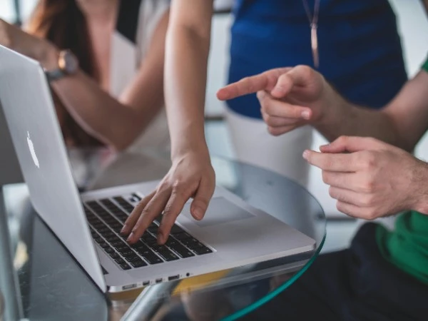 A team reviewing financial data on a laptop with an Insolvency Practitioner in Singapore during a corporate restructuring consultation.