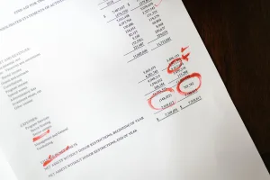 Financial statement with red ink annotations highlighting company losses and insolvent trading risk for Singapore directors.