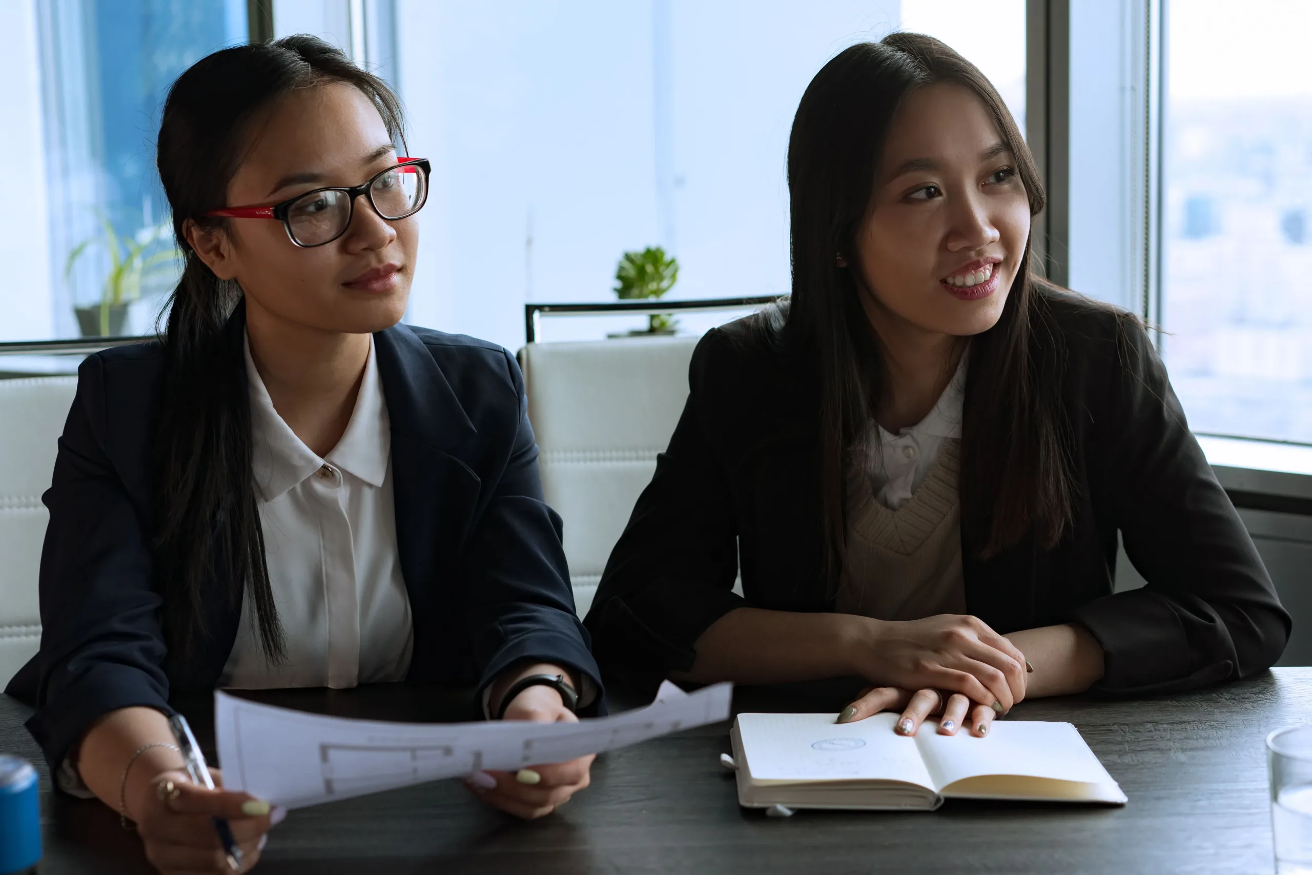 Two women engaged in a business meeting, discussing plans and ideas.